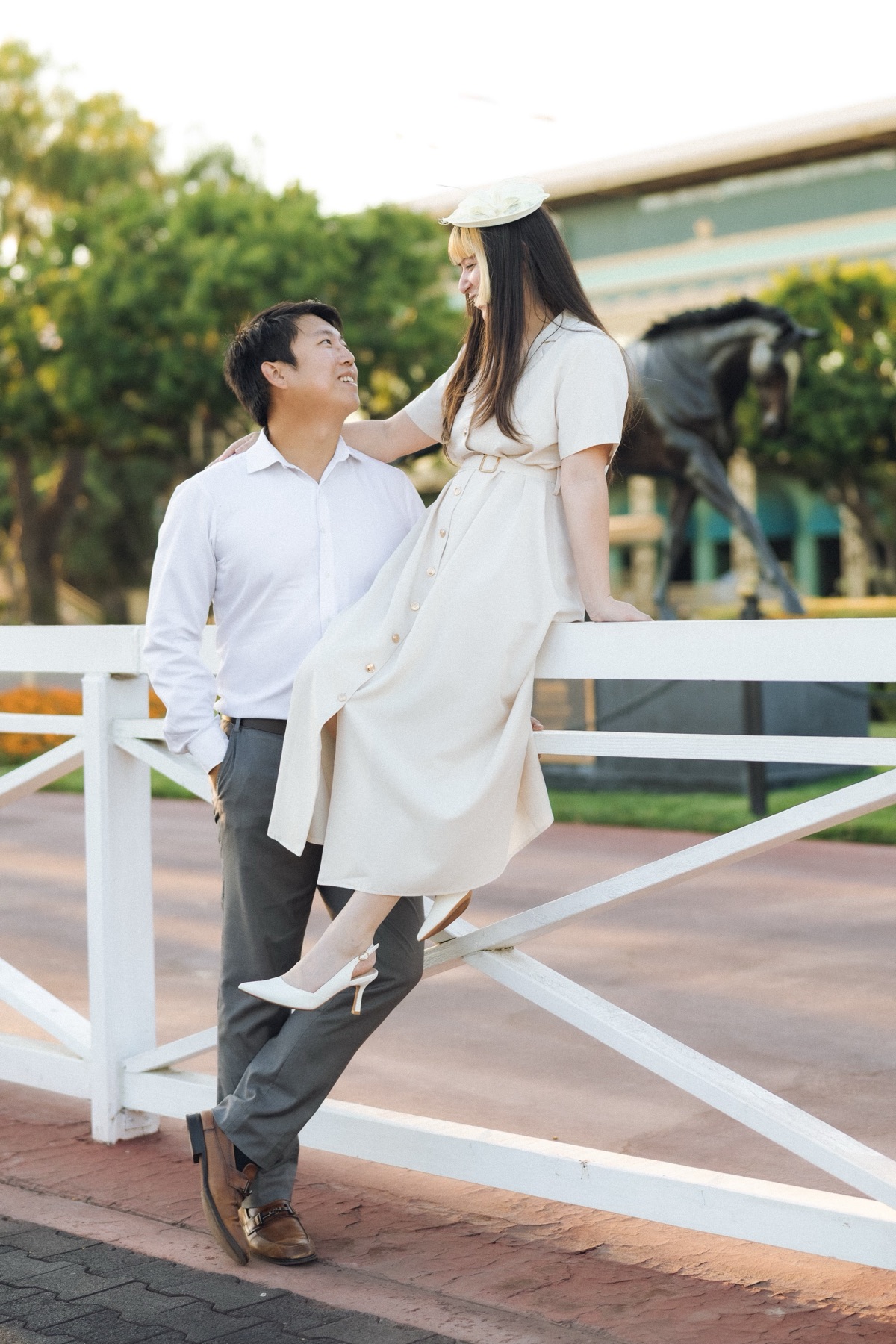 Joshua and Marina at the white paddock rails of Santa Anita Park